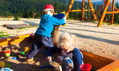 Venkovní hřiště s prolézačkami a houpačkami hned u boudy.